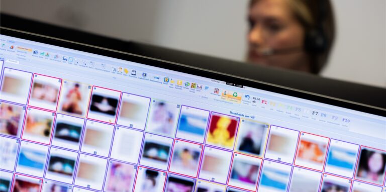 Eine Ermittlerin sitzt vor Monitoren mit unkenntlich gemachten Fotografien, die teilweise sexuellen Missbrauch zeigen, am Hinweistelefon im Landeskriminalamt.