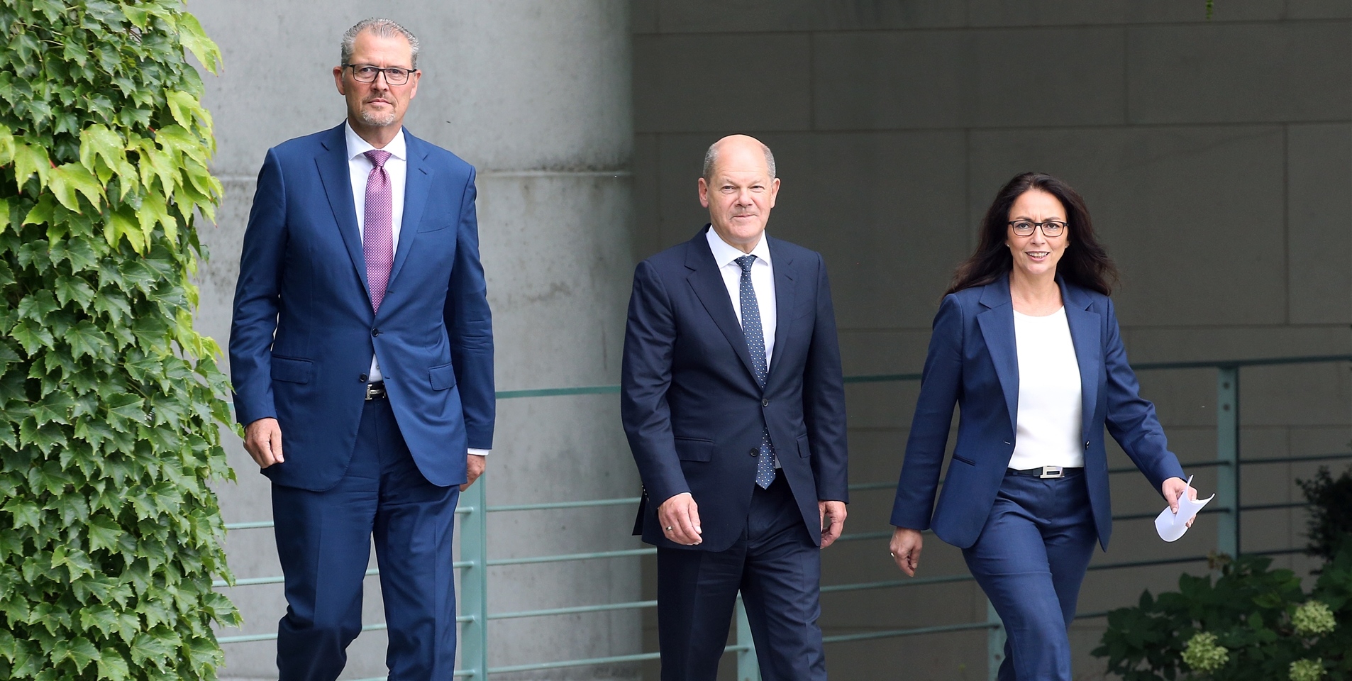 Rainer Dulger (l-r), BDA-Präsident, Bundeskanzler Olaf Scholz (SPD) und Yasmin Fahimi, Vorsitzende des Deutschen Gewerkschaftsbundes (DGB), gehen nach einer Konzertierten Aktion im Bundeskanzleramt durch den Garten um ein Statement abzugeben.