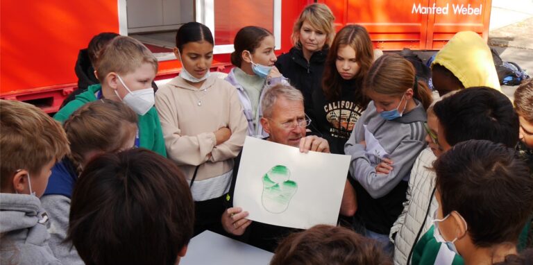 Künstler Manfred Webel zeigt den interessierten Schülern der Otto-Burrmeister-Realschule aus Recklinghausen eine Maltechnik.