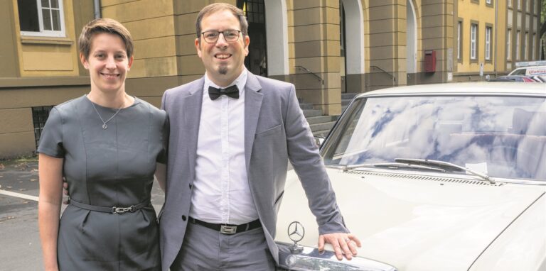 Ein Hochzeitspark vor einem Oldtimer.