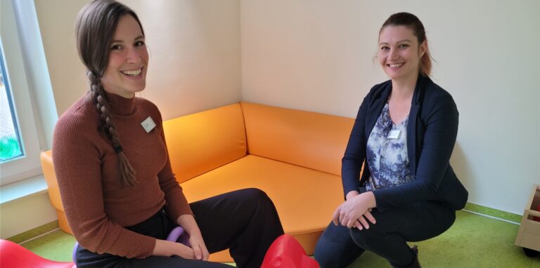 Zwei Frauen sitzen im Spielzimmer eines Kindergartens