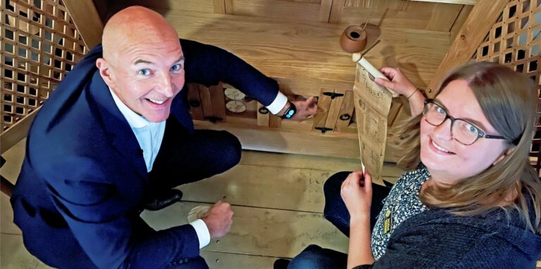 Dr. Georg Lunemann, Direktor des Landschaftsverbandes Westfalen-Lippe, und Noemi Sandmann vom Team Adventurebox Münster vor einem Rätsel an einem originalgetreuen römischen Schrank