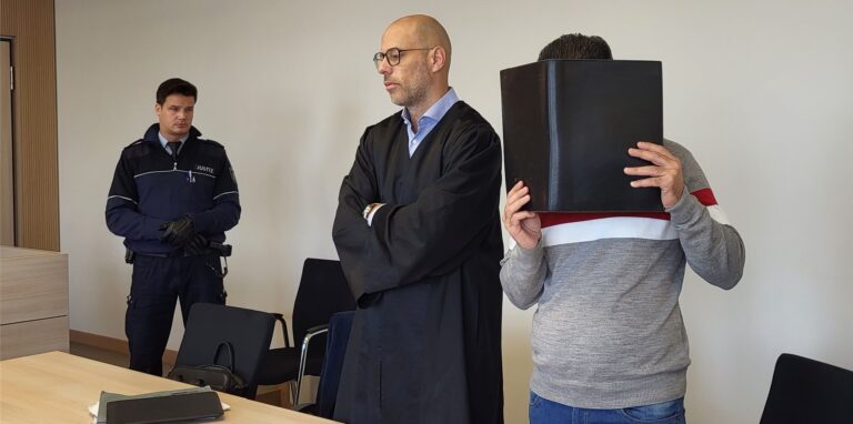 Der angeklagte Kinderarzt steht beim Prozessauftakt neben seinem Verteidiger.