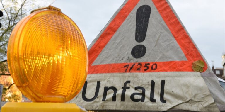 Ein Schild weist auf einen Verkehrsunfall hin.