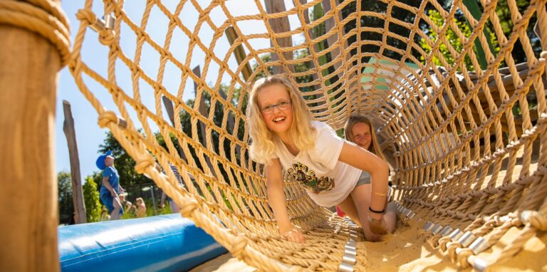Ein Mädchen klettert durch einen Tunnel auf dem Ketteler Hof in Haltern am See im Sommer 2022.