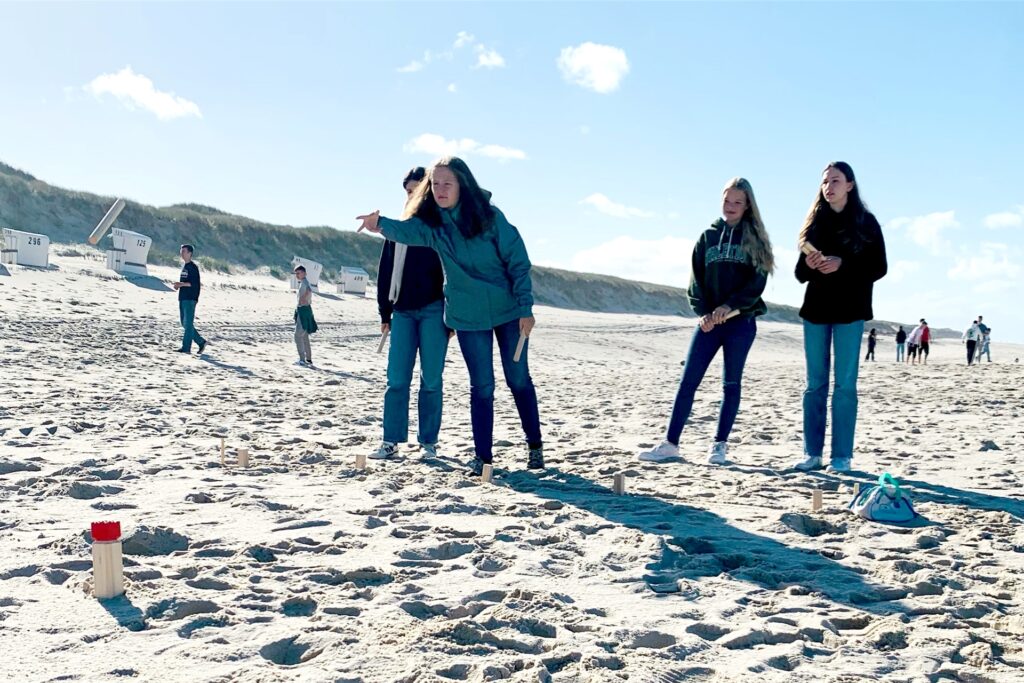 Jugendliche spielen am Strand.