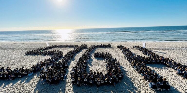 Die Hertener Schüler und Lehrer bilden am Strand den Schriftzug StGH nach.