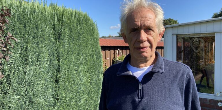 Udo Lipke, Vorsitzender des Kleingärtnervereins Gut Grün in Herten, steht vor seiner Gartenlaube.
