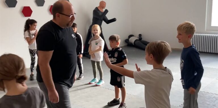 Trainer Maik Langenberg zeigt den Kindern, wie sie sich gegen Fremde wehren.