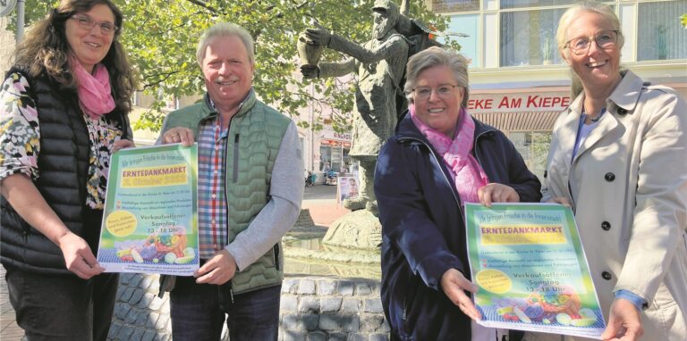 Andrea Kampmann und Bernd Zimmer sowie Angelika Westhoff-Haschke und Nicole Moenikes werden mit Plakaten für den Erntedankmarkt am 2. Oktober.