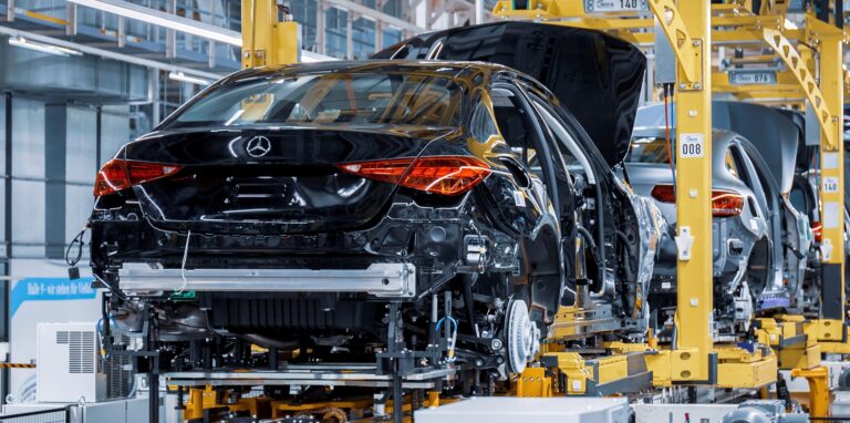 In der Produktion vom Mercedes-Benz hängen die neuen Fahrzeuge in einem Transportband.