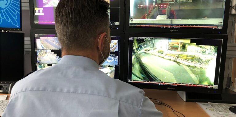 Ein Polizist schaut sich Bilder von Überwachungskameras an.