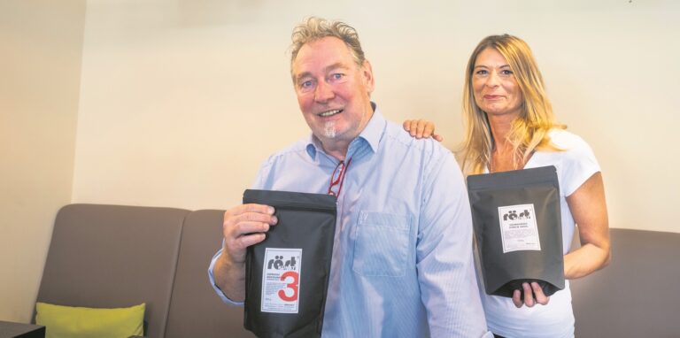 Ein Mann und eine Frau präsentieren frisch abgepackten Kaffee.