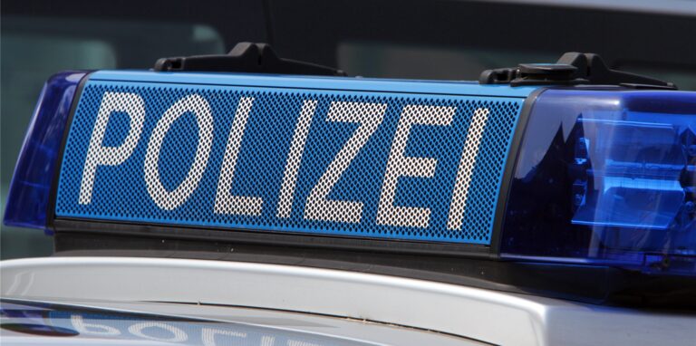 Ein Schild mit der Aufschrift Polizei auf einem Streifenwagen