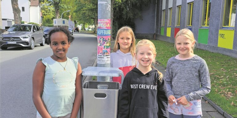 Vier Kinder stehen rund um einen neuen Abfallbehälter.