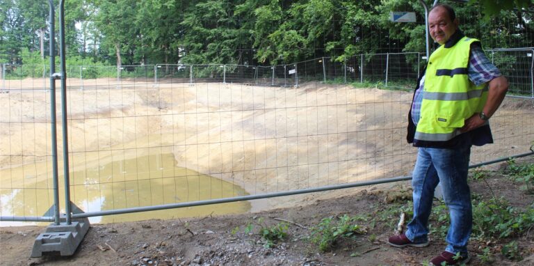 Frank Friedrich vom V+E Waltrop  steht an einem Bauzaun rund um ein Regenrückhaltebecken