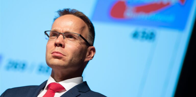 Christian Blex, Landtagsabgeordneter der NRW-AfD, steht auf einem Podium.