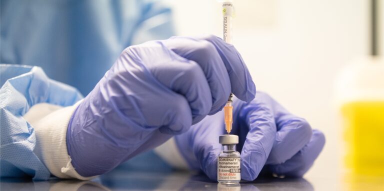 Ein Mitarbeiter eines Impfzentrums zieht eine Spritze mit dem an die Omikron-BA.1-Variante angepassten Impfstoff Comirnaty von Biontech und Pfizer auf.