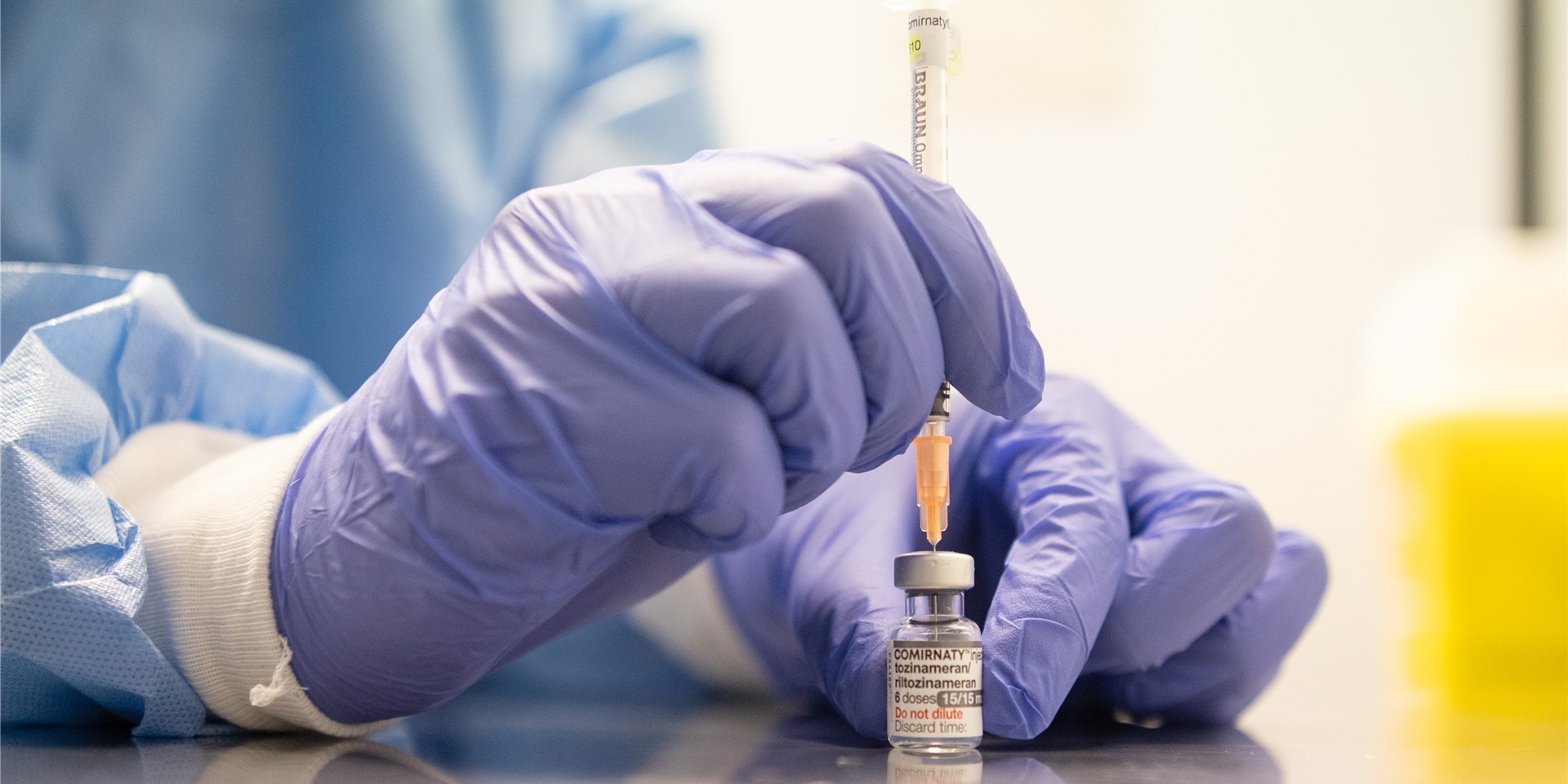 Ein Mitarbeiter eines Impfzentrums zieht eine Spritze mit dem an die Omikron-BA.1-Variante angepassten Impfstoff Comirnaty von Biontech und Pfizer auf.