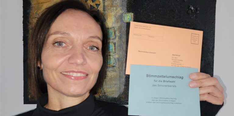 Verwaltungsmitarbeiterin Anika Windeck aus Oer-Erkenschwick hält die Umschläge für die Seniorenbeiratswahl hoch.