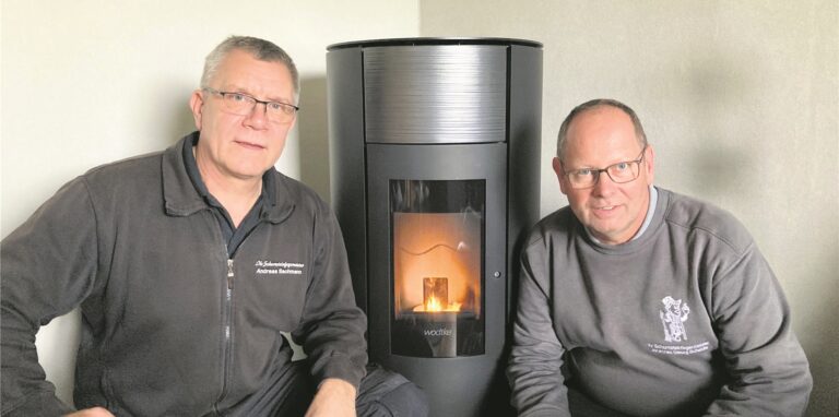 Die Schornsteinfeger Andreas Bachmann und Georg Scheidle vor einem Pellet-Ofen.
