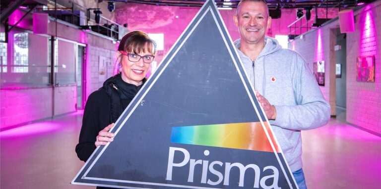 Die ehemalige Prisma-Mitbetreiberin Martina Tempelmann und Thomas Averkamp (DJ Tom) halten ein „Prisma“-Schild hoch.