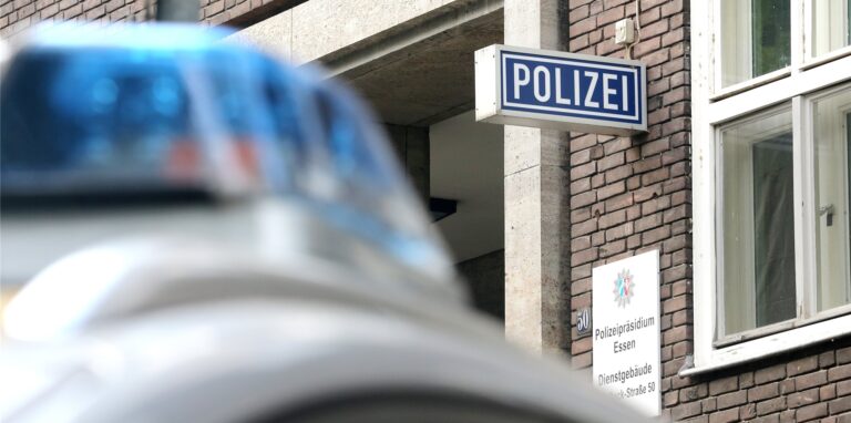 Ein Polizeiwagen steht vor dem Polizeipräsidium Essen.