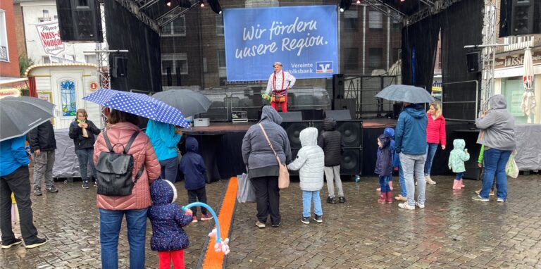 Ein Zauberer steht bei strömendem Regen auf der Bühne.