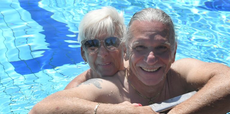 Frau und Mann lächeln erfreut am Rand des 50-Meter-Beckens im Parkbad Nord beim Freibadfest 2022.