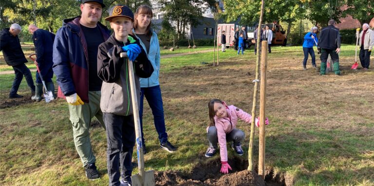 Jonas (11) pflanzt gemeinsam mit seiner Schwester Marie (8) sowie den Eltern Nicole und Thorben Ganswind einen Dülmener Herbstrosenapfel.