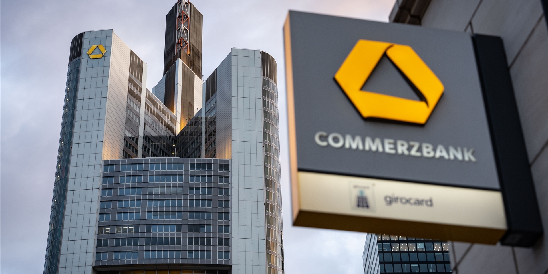 Das Logo des Commerzbank ist an einer Filiale in Sichtweite der Zentrale der Commerzbank (l) angebracht.