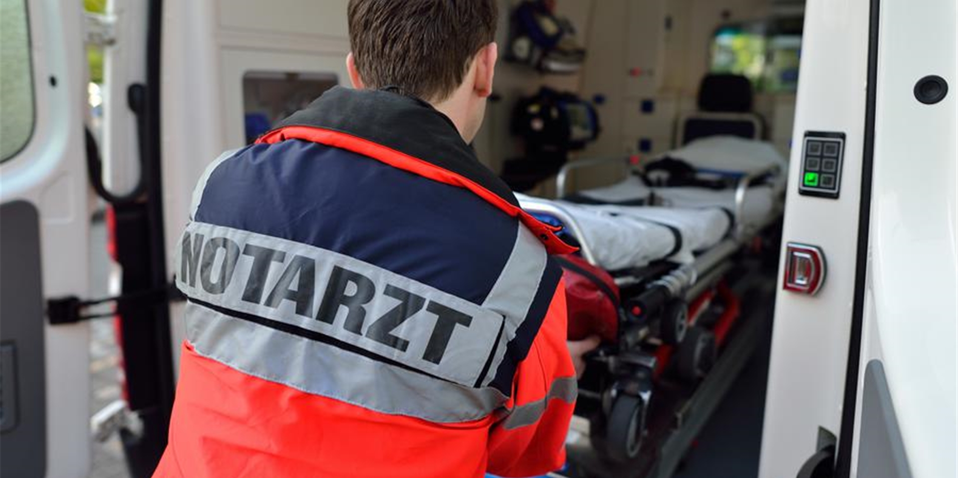 Symbolbild: Ein Notarzt holt eine Liege aus einem Krankenwagen.
