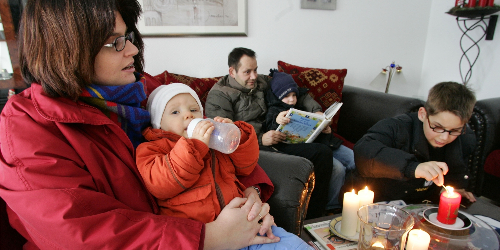 Eine Familie sitzt im Wohnzimmer.