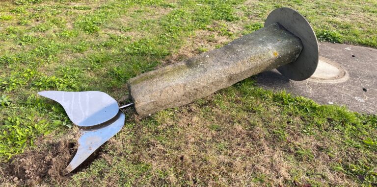 Auf dem Waltroper Zechengelände liegt eine Kunstfigur aus Stahl, die auf einen Steinsockel montiert ist, auf dem Boden.