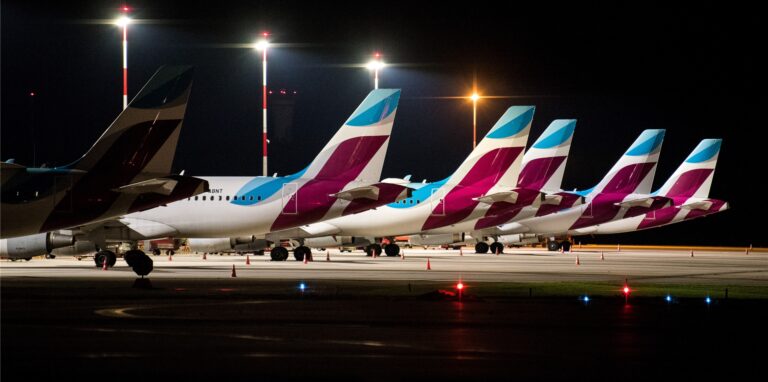 Flugzeuge von Eurowings stehen in einer Reihe am Boden.