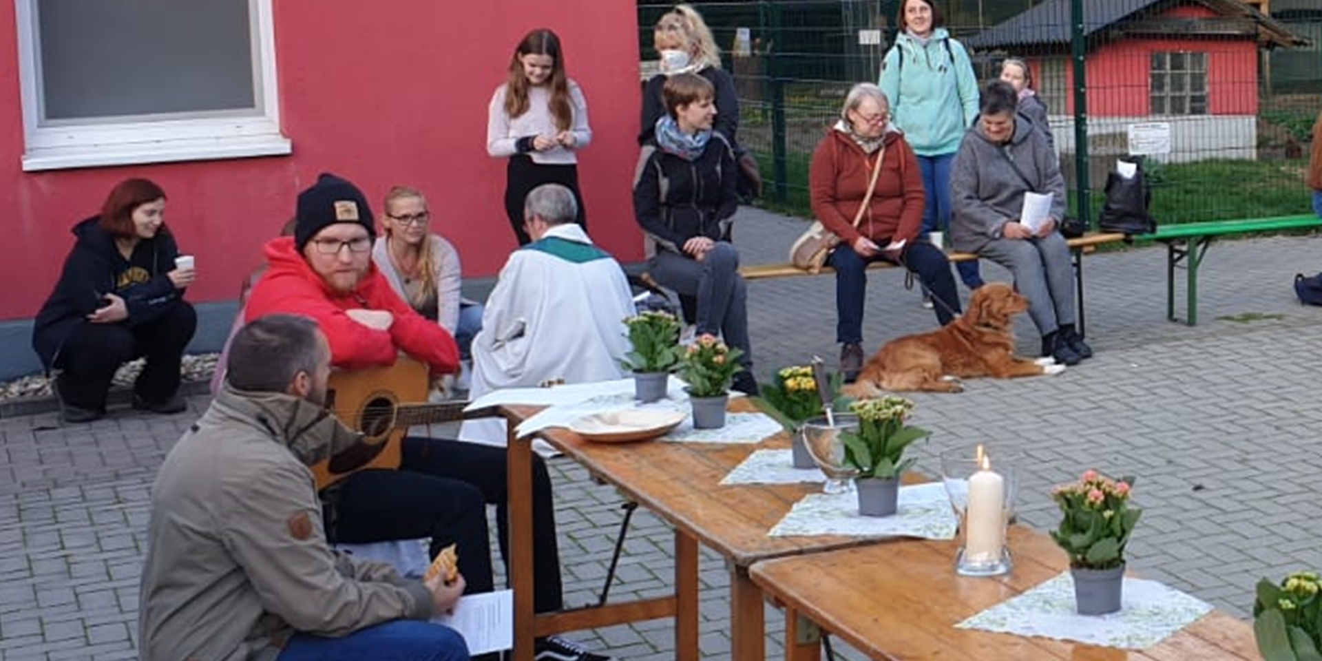 Menschen sitzen am Tierheim Dorsten anlässlich eines Gottesdienstes zum Welttierschutztag.