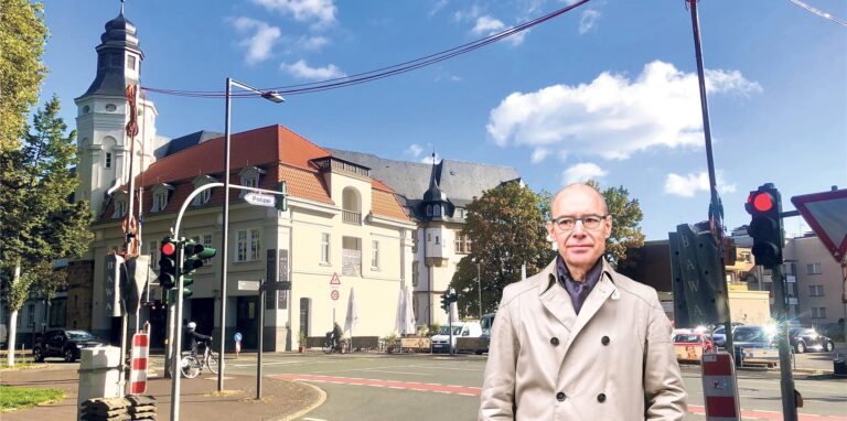 Mann steht vor historischem Gebäude