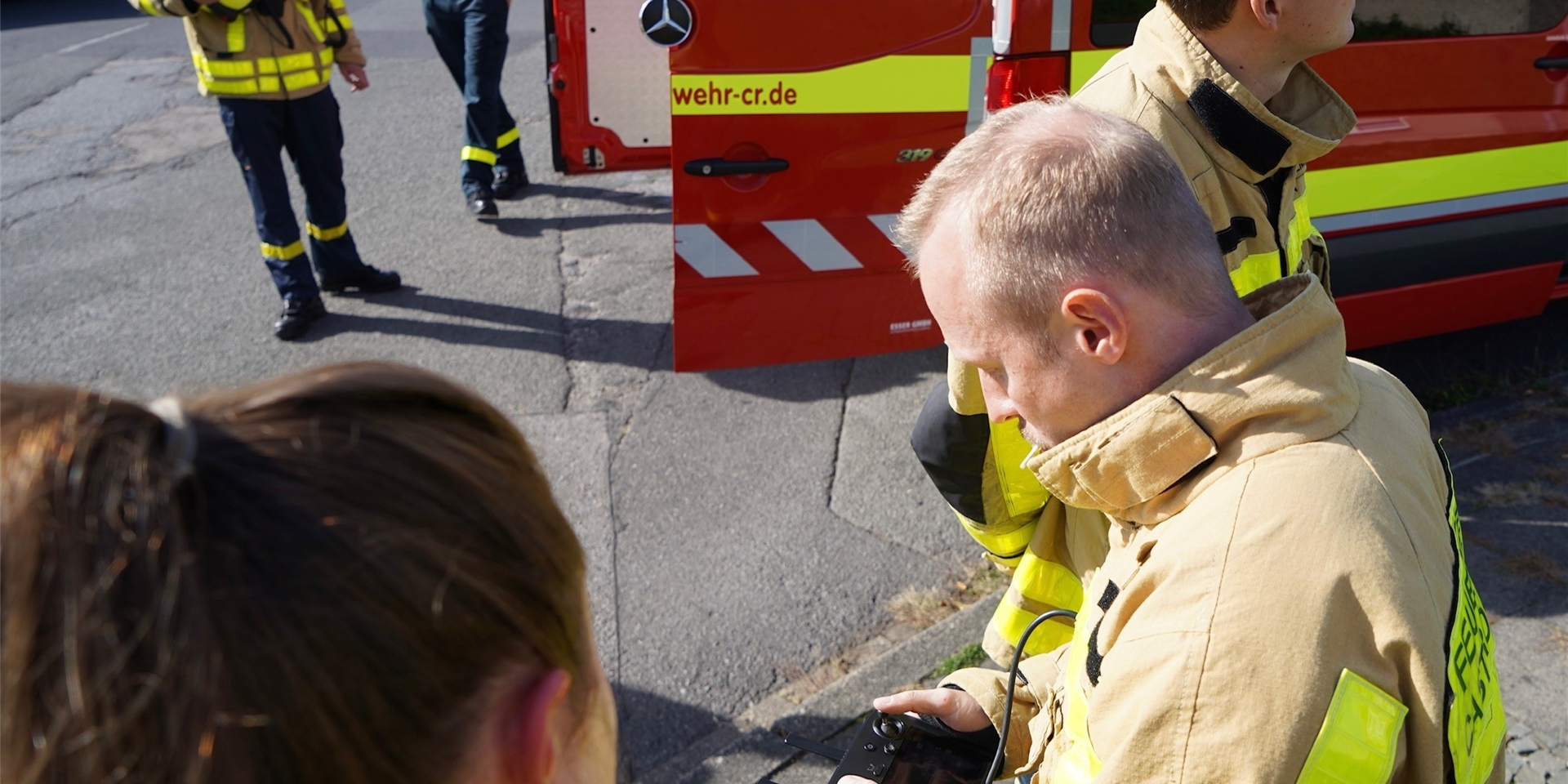 Ein Feuerwehrmann hat den Joystick für eine Drohne in der Hand.