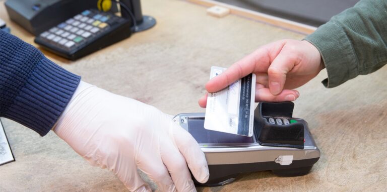 Händler hält Kundem ein Kartenlesegerät zum Bezahlen mit der Girocard hin.
