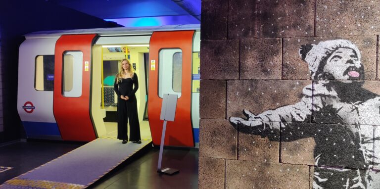 Kuratorin Virginia Jean im britischen U-Bahn-Wagen, rechts eine Hälfte des berühmten Banksy-Graffitis „Seasons Greetings“.