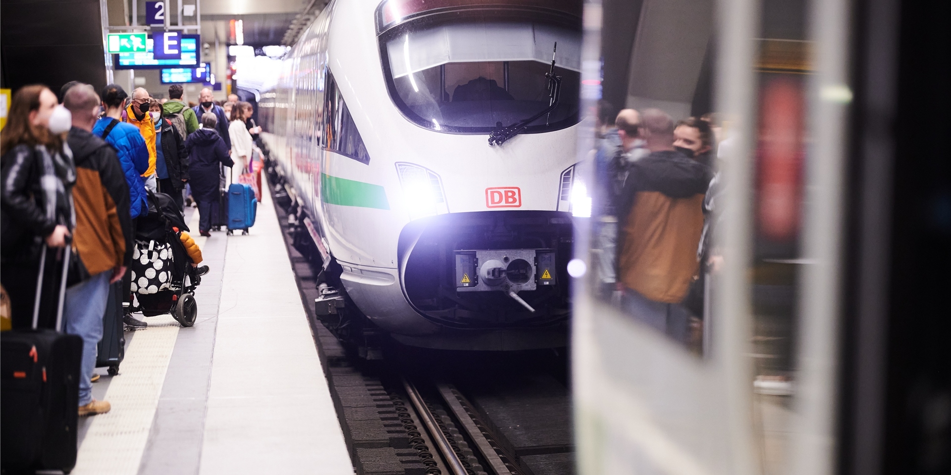 Viele Menschen stehen am Gleis im Hauptbahnhof Berlin, als ein ICE einfährt.