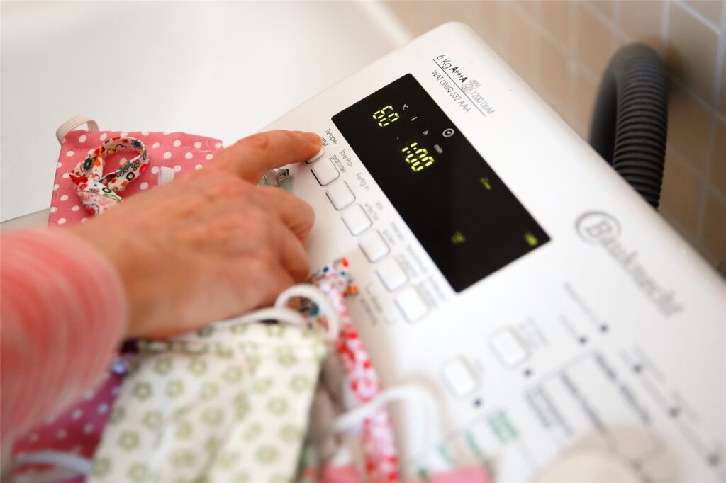 Eine Frau programmiert eine Waschmaschine