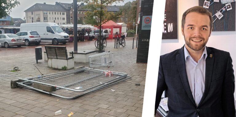 Ein umgekippter Bauzaun und ein Einkaufswagen sowie Müll finden sich rund um die Stadthalle Waltrop. Rechts im Bild: Bürgermeister Marcel Mittelbach.