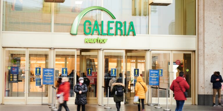 Menschen kommen aus oder gehen in den Galeria Kaufhof am Alexanderplatz.