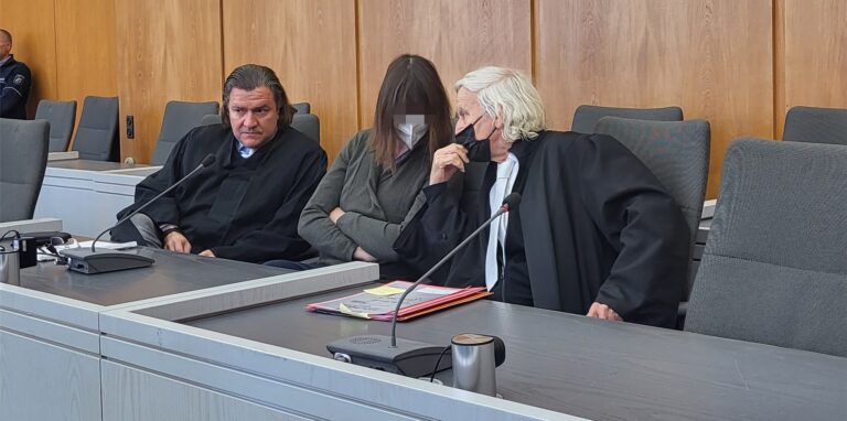 Eine Angeklagte und zwei Anwälte im Gerichtssaal