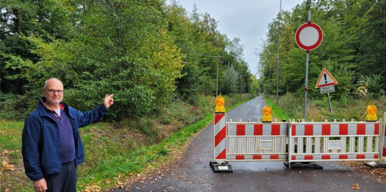 Anwohner Wilhelm Rehr zeigt auf die gesperrte Holthäuser Straße in Oer-Erkenschwick.