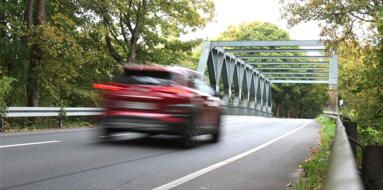 Die Hafenbrücke (Viktorstraße) in Waltrop, im Vordergrund ein vorbeifahrendes Auto.