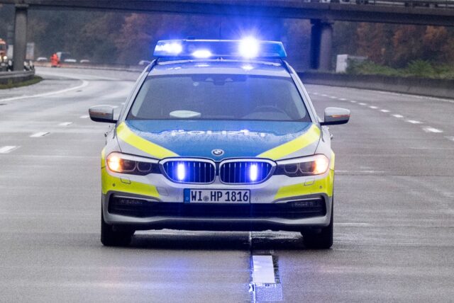 Ein Polizeiauto fährt über die Autobahn.