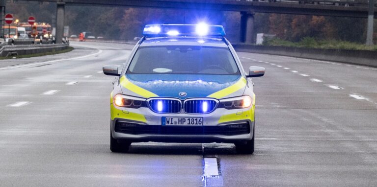 Ein Polizeiauto fährt über die Autobahn.