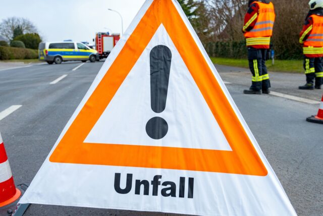 Ein Warndreieick steht nach einem Unfall auf einer Bundesstraße.